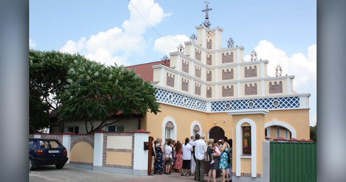 People are gathered at the door of a building in a Greek Catholic parish.