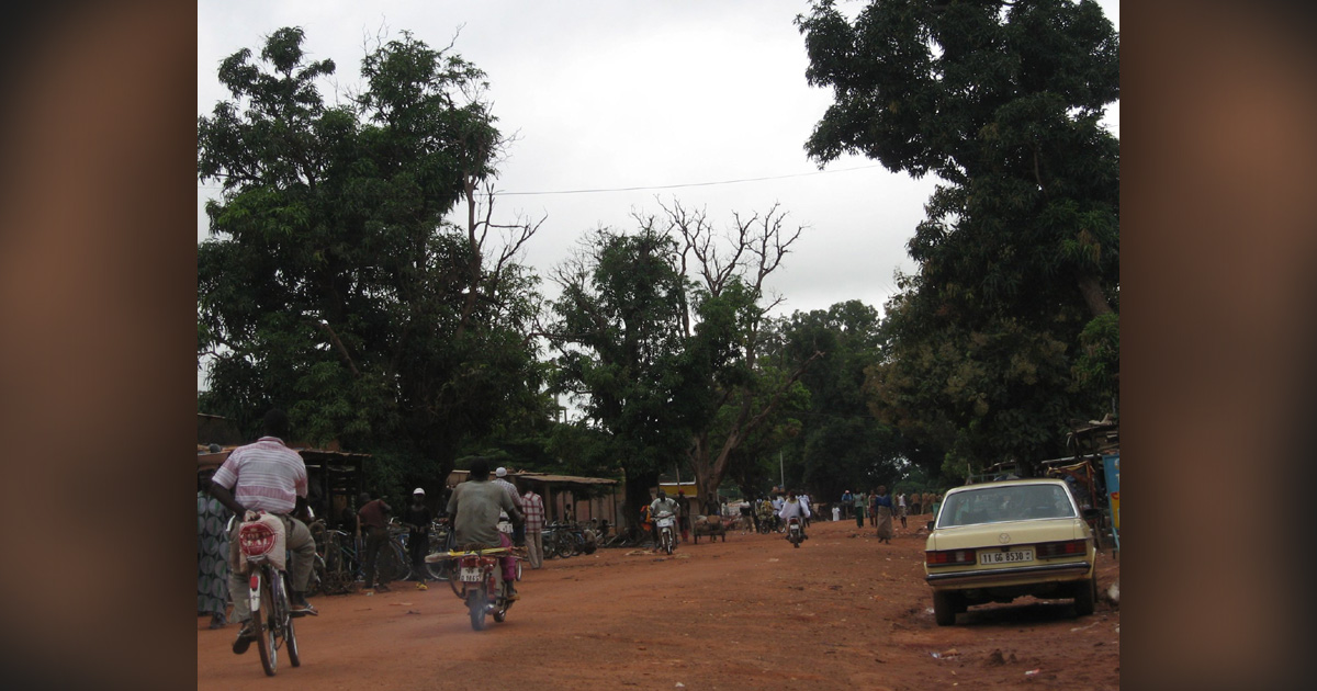 A dirt street in what appears to be a village.