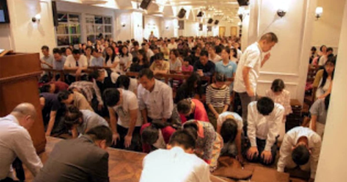 A large group of Chengdu Early Rain Church members are kneeling in prayer together. 