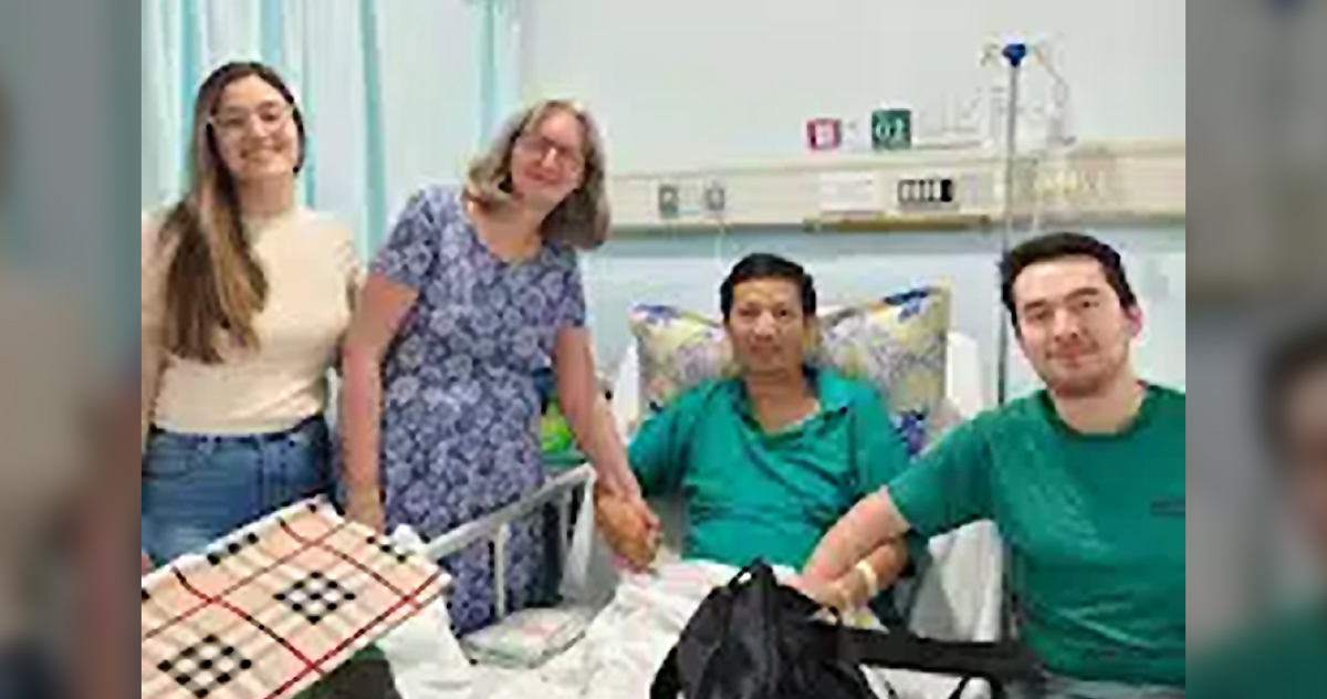 John Cao smiles as his wife, daughter, and son visit him in the hospital.