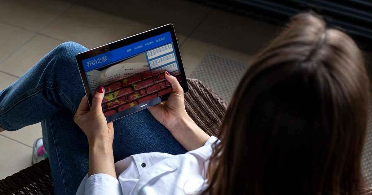 Woman holding a tablet with a website open; website looks like the Chinese flag is taking over