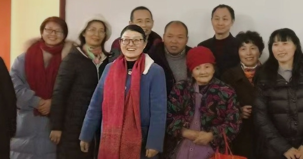 Zhang Mei is smiling. She is surrounded by others who also look happy.