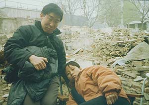 Dr. Xu Yonghai & Li Shanna in the remains of their house