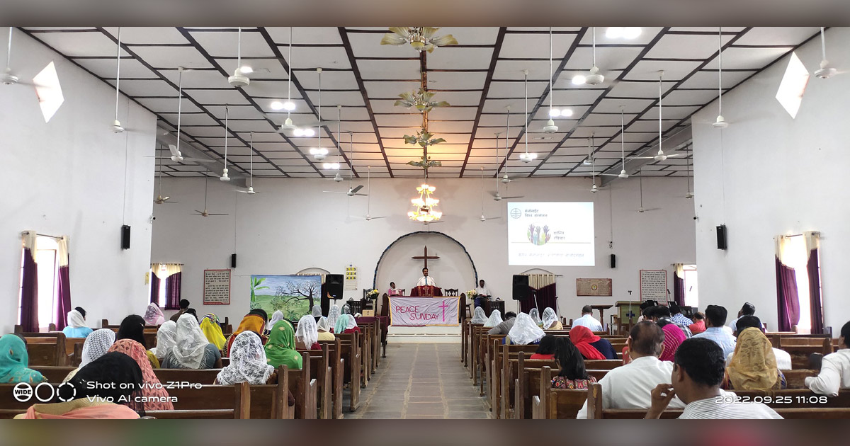 A brightly lit church building is filled with people.