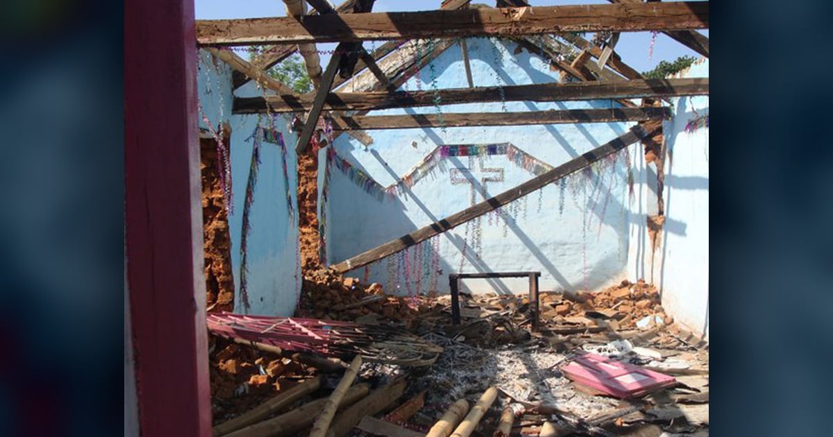 A burned out church still shows a cross on the front wall.