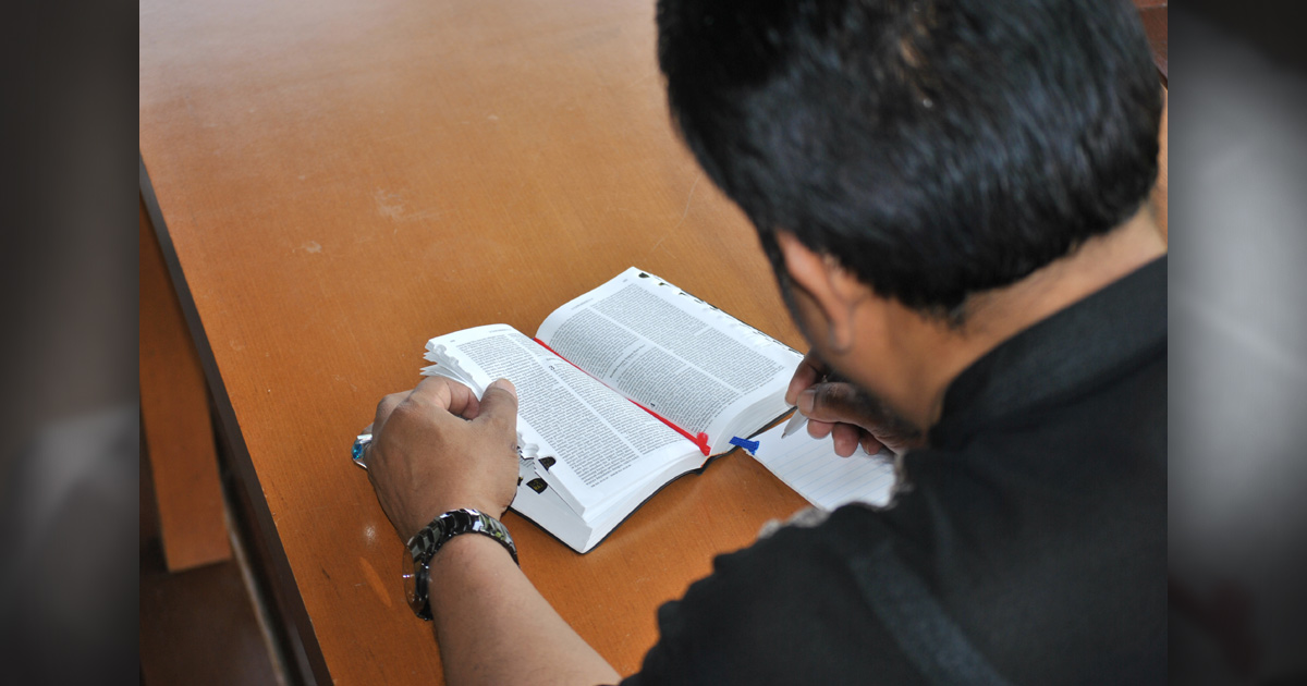 A man studying the Bible and taking notes.