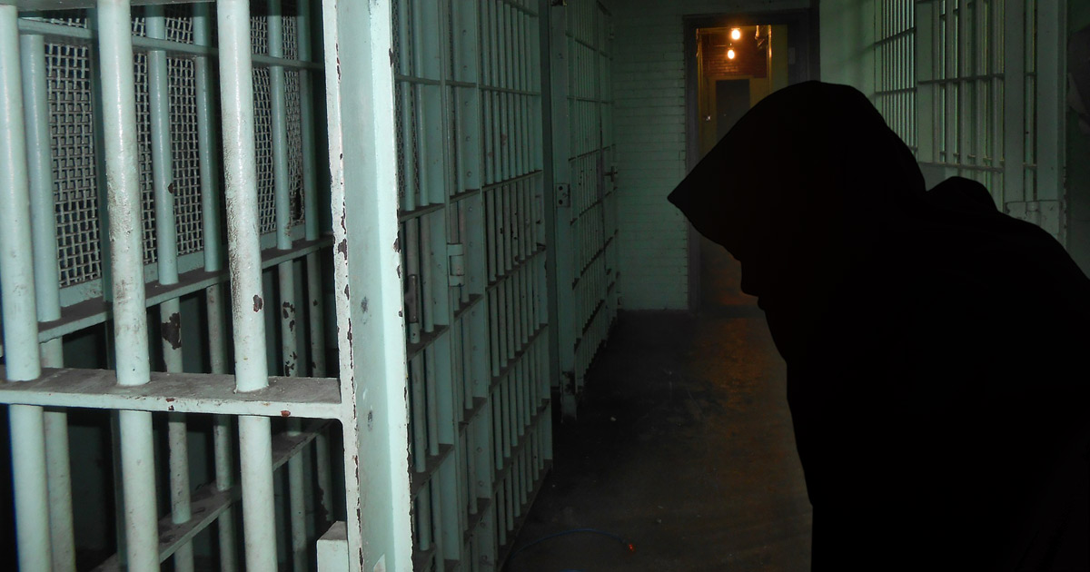 Silhouette of a woman, prison bars