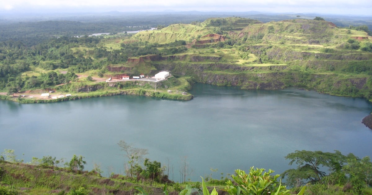 A lake is surrounded by tree covered hills.. A lake is surrounded by tree covered hills.