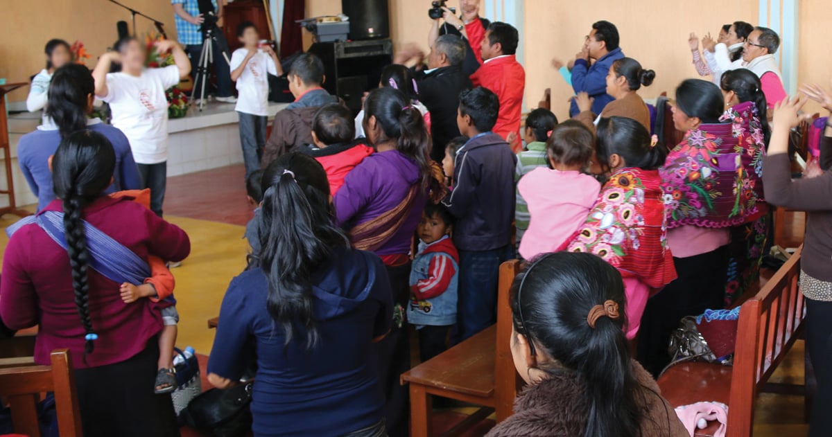 A congregation in Mexico is standing together.