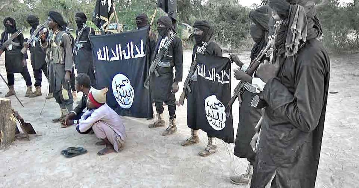 Militants are holding a black flag with Arabic letters on it.