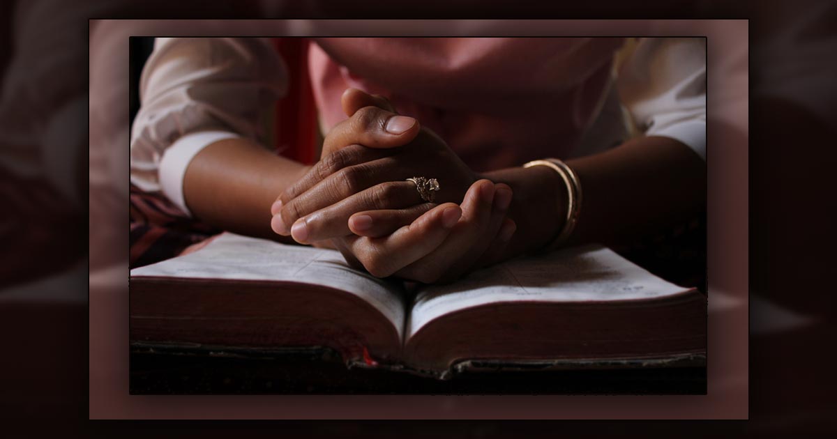 Praying hands resting on a Bible - Photo: Pixabay