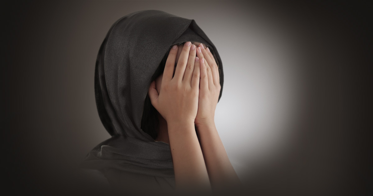 A girl in a hijab covering her face.
