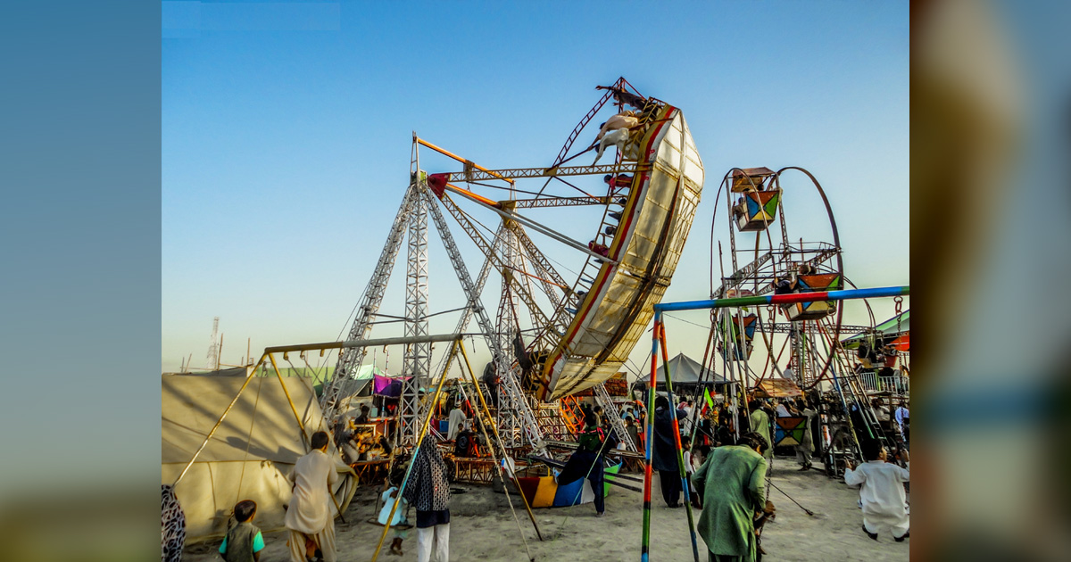 Several people are enjoying the rides at a local fair.