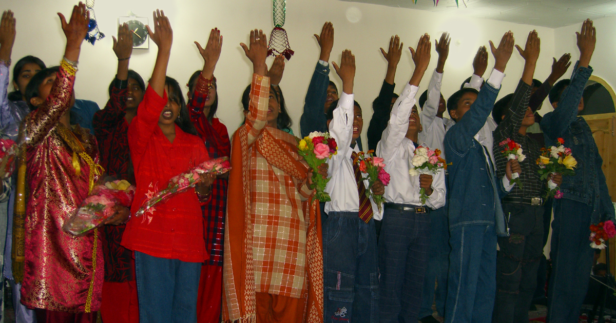Young people raising their hands in worship.