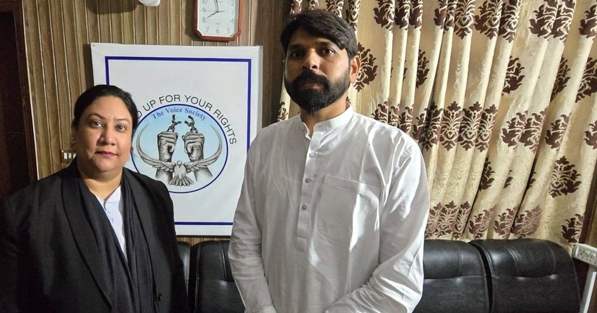 Zimran Asim is standing with his lawyer. There is a poster behind them which reads, "[Stand] up for your rights. The Voice Society." 