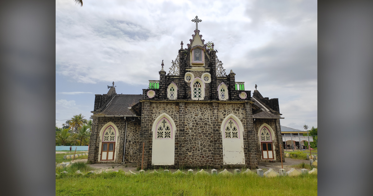 A small, ornately decorated church is set against light blue clouds.