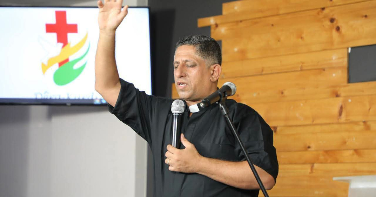 Nihad Hassan is standing with one hand raised while praying. Nihad Hassan is standing with one hand raised while praying.