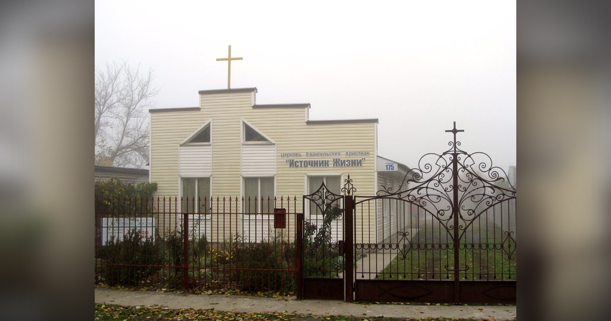 A church is behind an iron gate.
