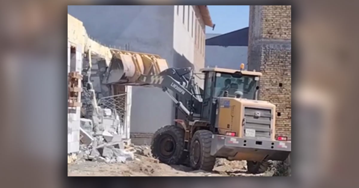 A bulldozer is destroying a building. 