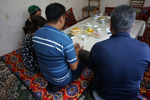 Uzbeks gathered around a table, praying - Photo: World Watch Monitor; www.worldwatchmonitor.org