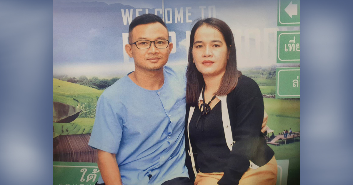 Y Quynh Bdap and his wife are sitting in front of a mural.