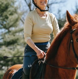 A woman is riding a horse.