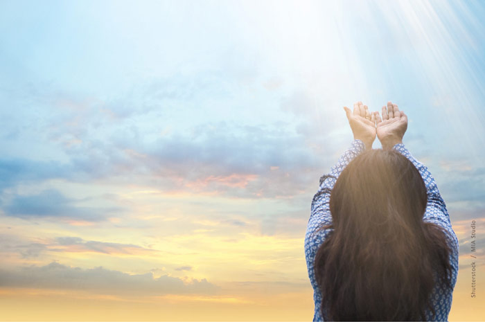 A woman lifting her hands toward heaven.