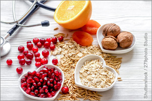 Fruit, grains, and nuts are arranged on a table and in heart-shaped bowls. A stethoscope sits beside the food.