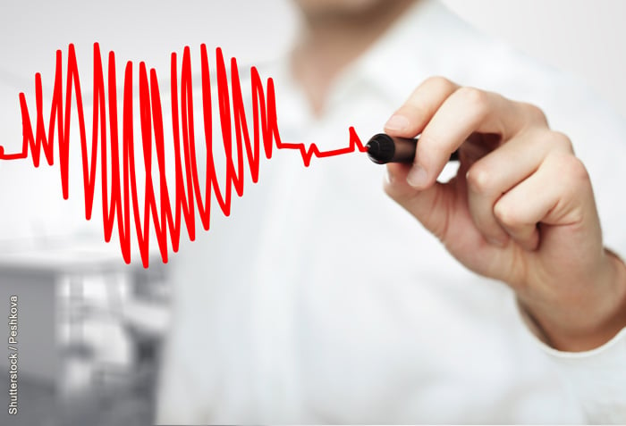 A man is drawing the pattern of a heartbeat. It forms the shape of a heart.