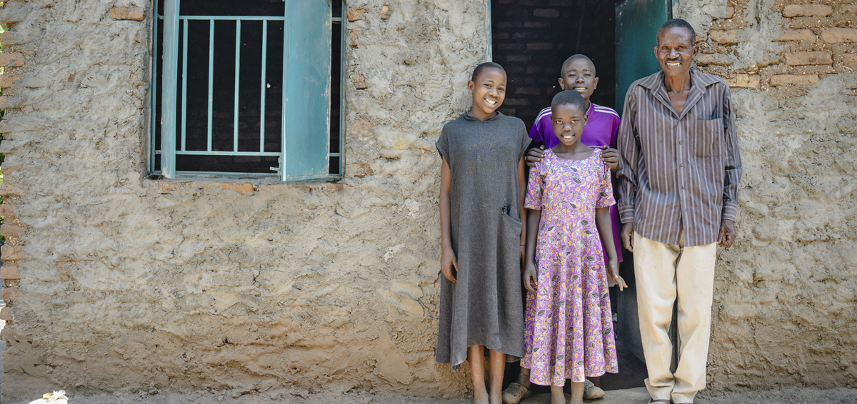 A smiling family stands in a doorway.