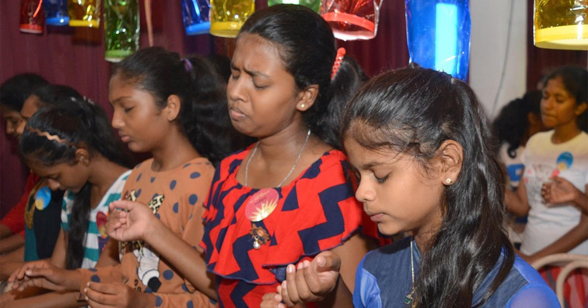 Women and girls are praying together.